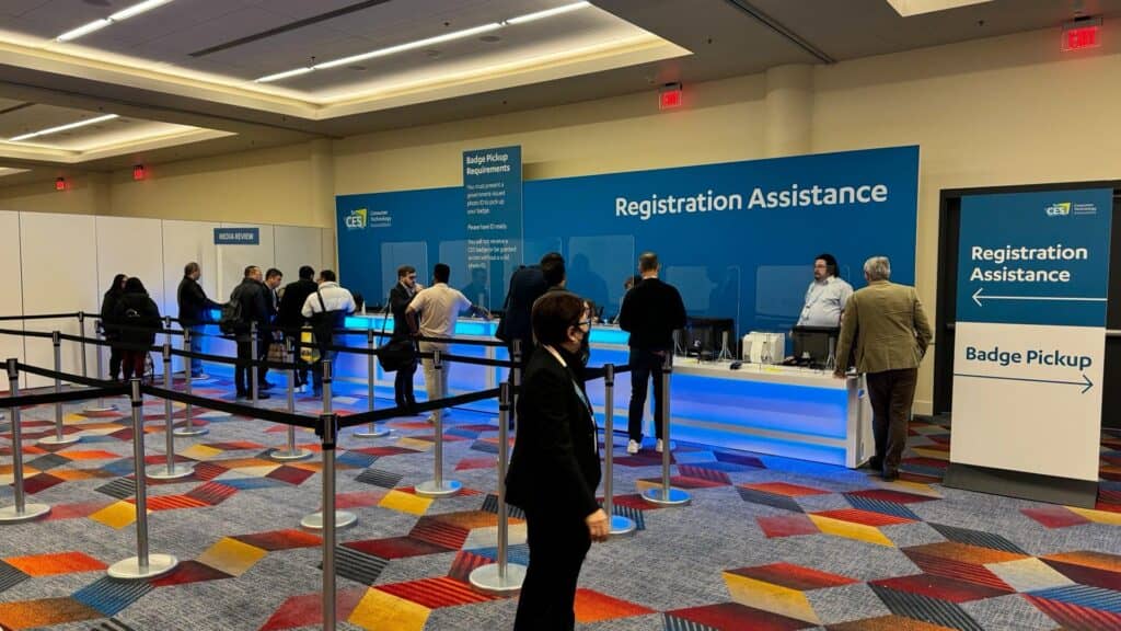 people lining up to print badge at conference