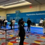 people lining up to print badge at conference